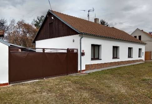 A house with a brown gate

Description automatically generated